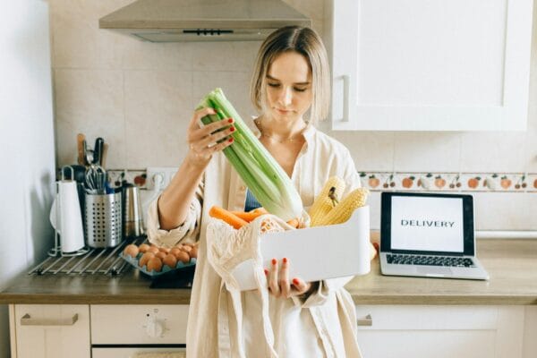 Woman in White Robe Holding Green Plastic Pack